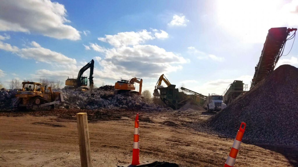 Heavy equipment piles large rocks and gravel at a construction site