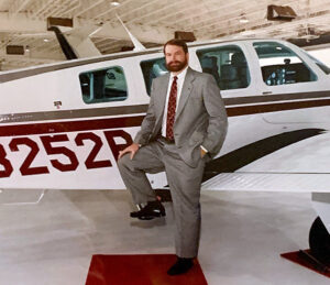 Peeler in front of airplane 1980s