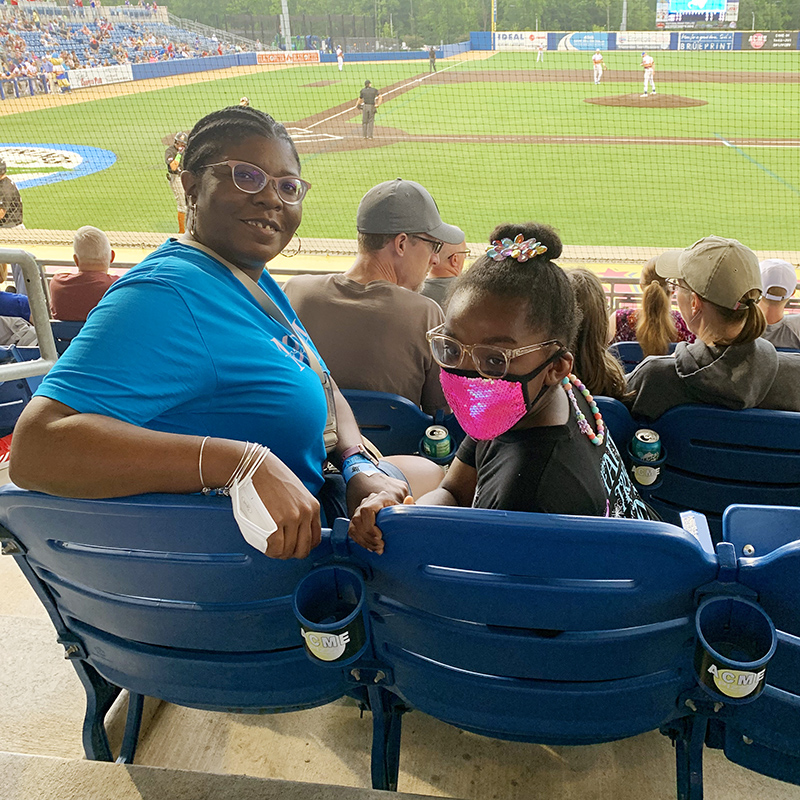 Employee and family member at a baseball game
